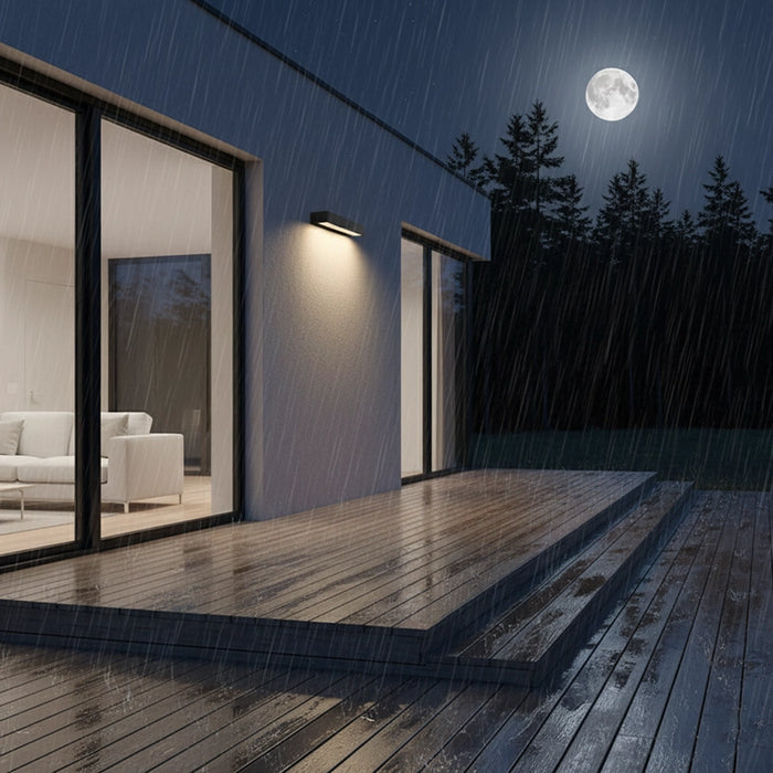 Modern house exterior with a wooden deck during a rainy night under a full moon.