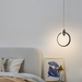 Modern pendant light hanging above a bed in a bedroom setting.