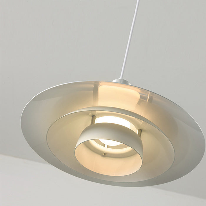 Modern pendant light with metallic finish on a neutral background