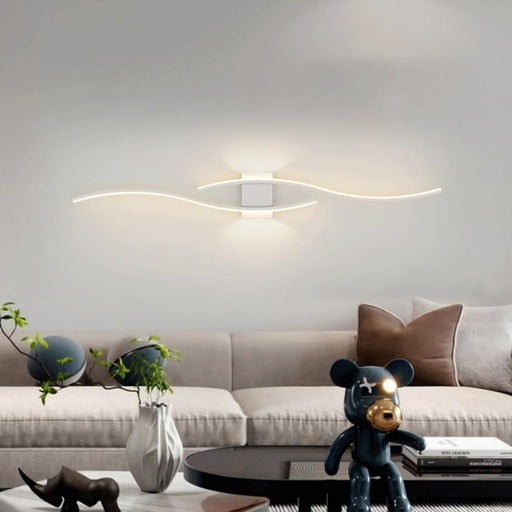 Modern living room with a beige sofa, decorative items, and wall lights.