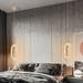 Modern bedroom with gray walls, a bed, and hanging lights.