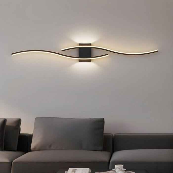 Modern wall light fixture in a living room setting with a gray sofa.