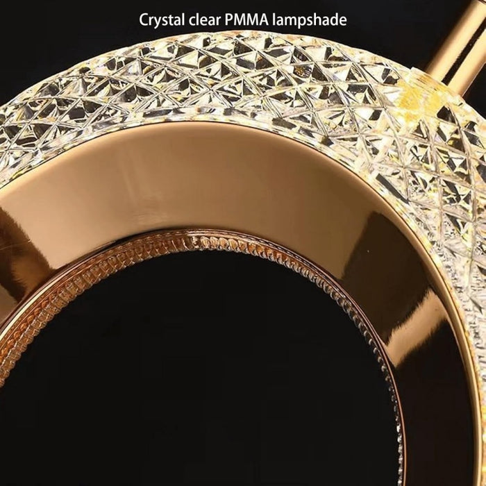 Crystal clear PMMA lampshade with gold trim on a black background