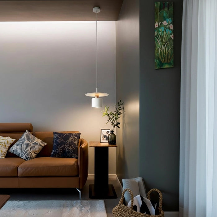 Modern living room with brown sofa, decorative pillows, and a hanging light fixture.