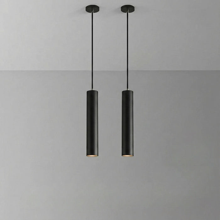 Two black pendant lights hanging against a gray background