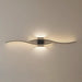 Modern wall light fixture in a living room setting with a gray sofa.