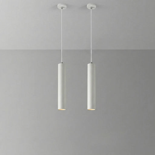 Two cylindrical pendant lights hanging against a gray background