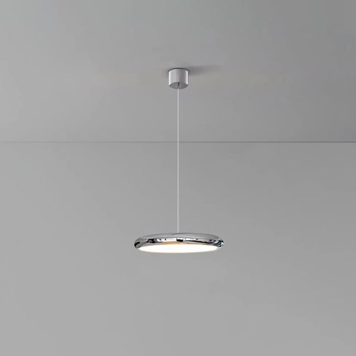 Modern pendant light hanging from a ceiling on a gray background