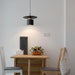 Small dining area with a table, chairs, and a hanging light fixture.
