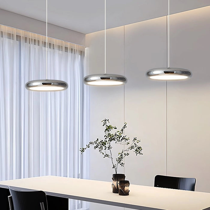Modern dining room with pendant lights, table, and chairs.