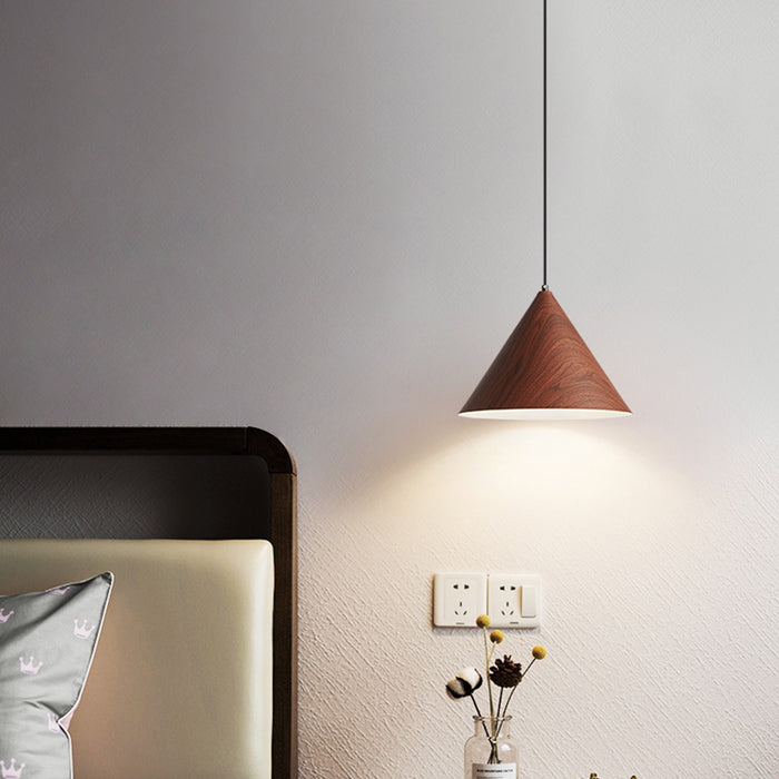 Wooden pendant light hanging above a bed in a bedroom setting.