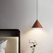 Wooden pendant light hanging above a bed in a bedroom setting.