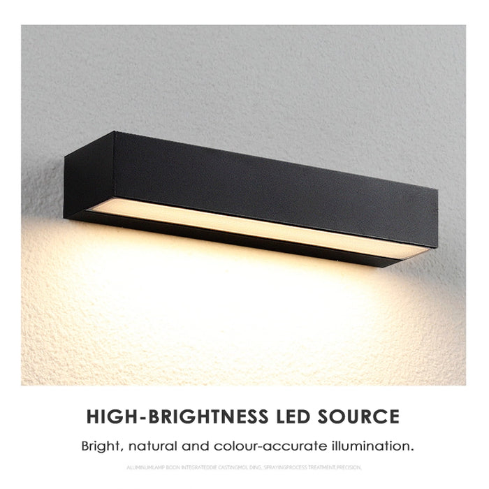 Black rectangular wall light fixture on a gray wall with text 'HIGH-BRIGHTNESS LED SOURCE'.