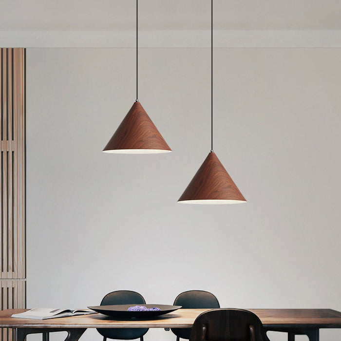 Two wooden pendant lights hanging above a dining table with chairs.