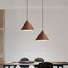 Two wooden pendant lights hanging above a dining table with chairs.