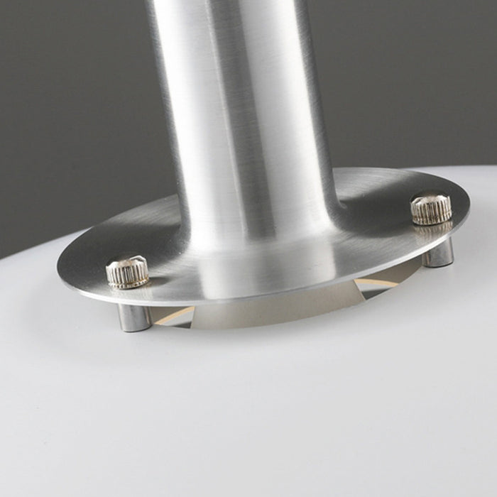 Close-up of a metallic stand with three screws on a gray background