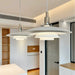 Modern pendant lights hanging in a room with white walls and wooden shelves.