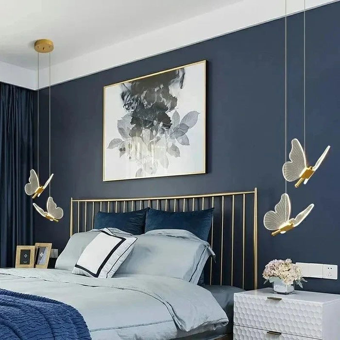 Modern bedroom with dark blue walls, gold headboard, and decorative lighting fixtures.