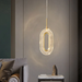 Modern pendant light hanging in a room with a sofa and decorative items.